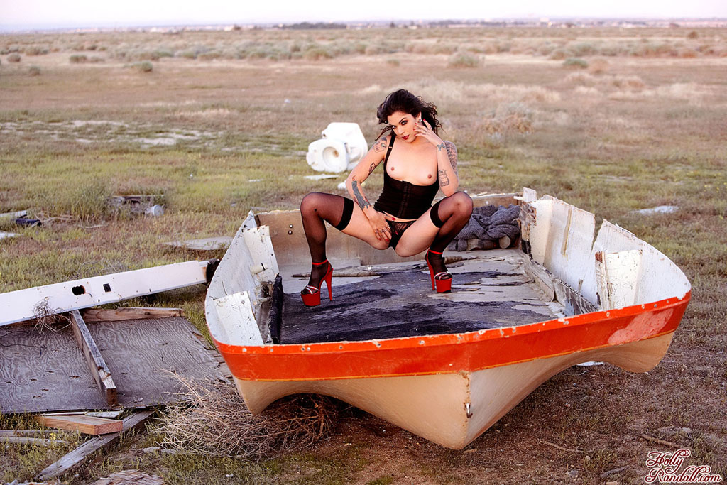 Kayla Jane stripping naked by a shipwrecked boat in a desolate field